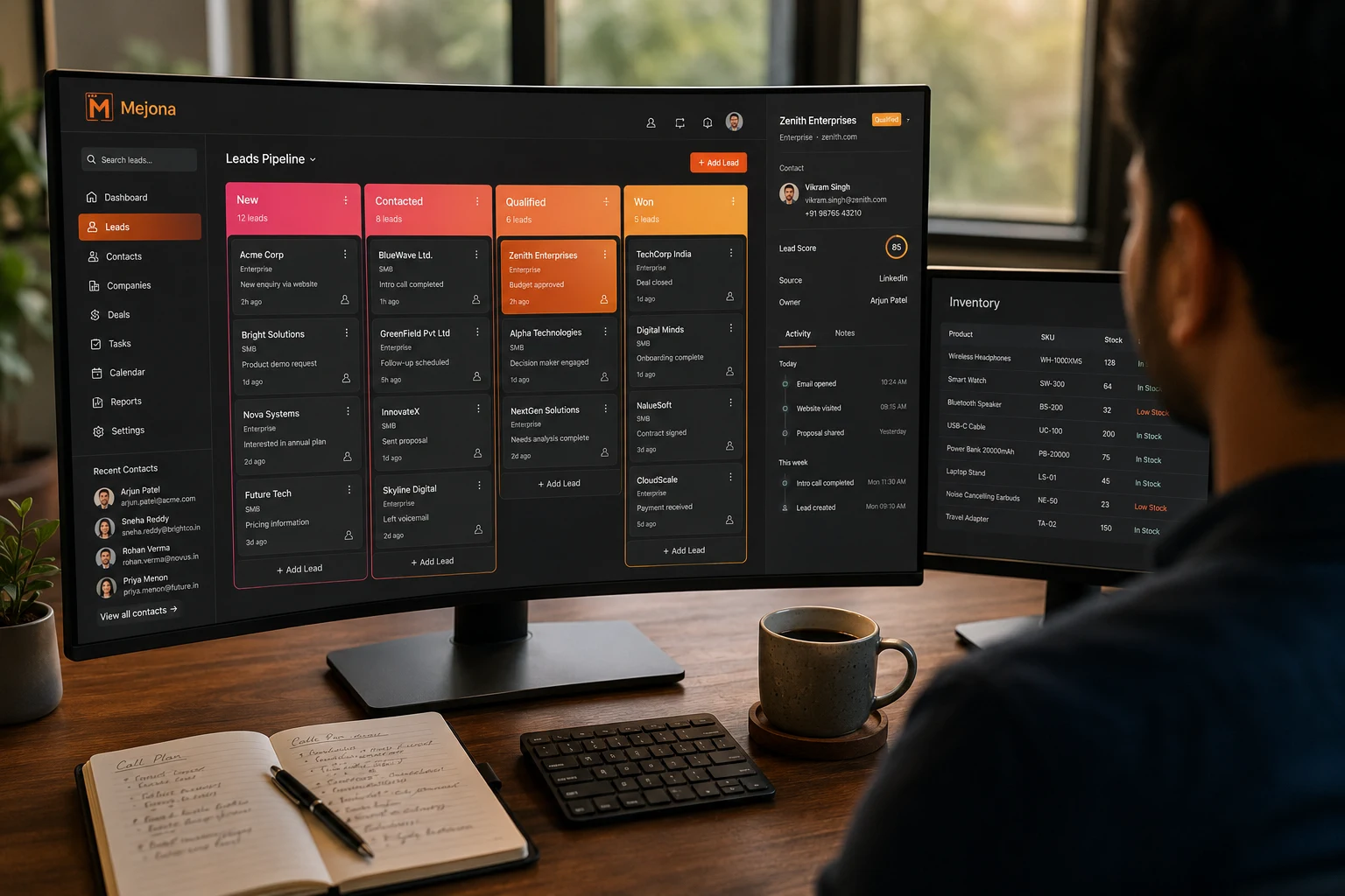 An over-the-shoulder view of a Mejona CRM Leads Pipeline Kanban board on an ultrawide monitor with a contact details panel and a second monitor showing the Inventory module